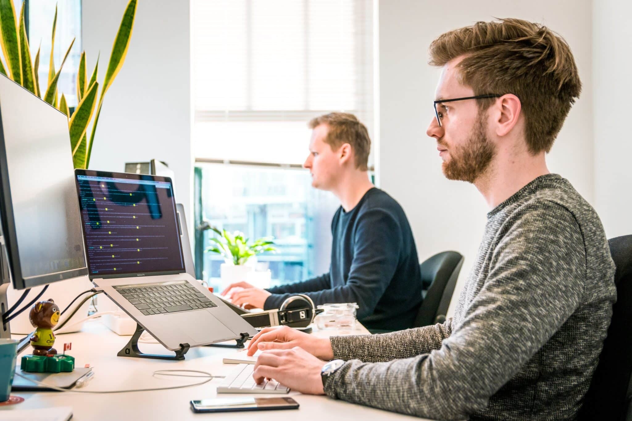 Two men working on their laptops